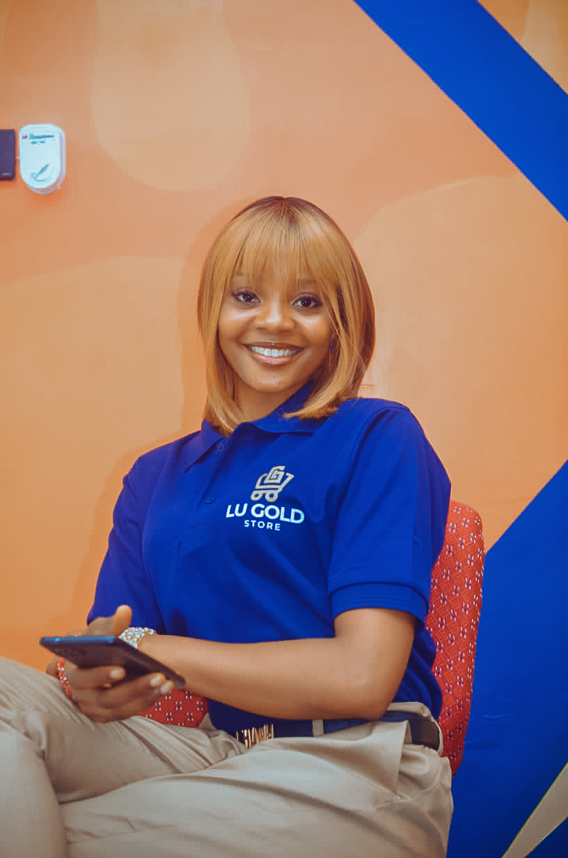 Lu Gold Store sales advisor smiling in a branded polo at the Abuja showroom