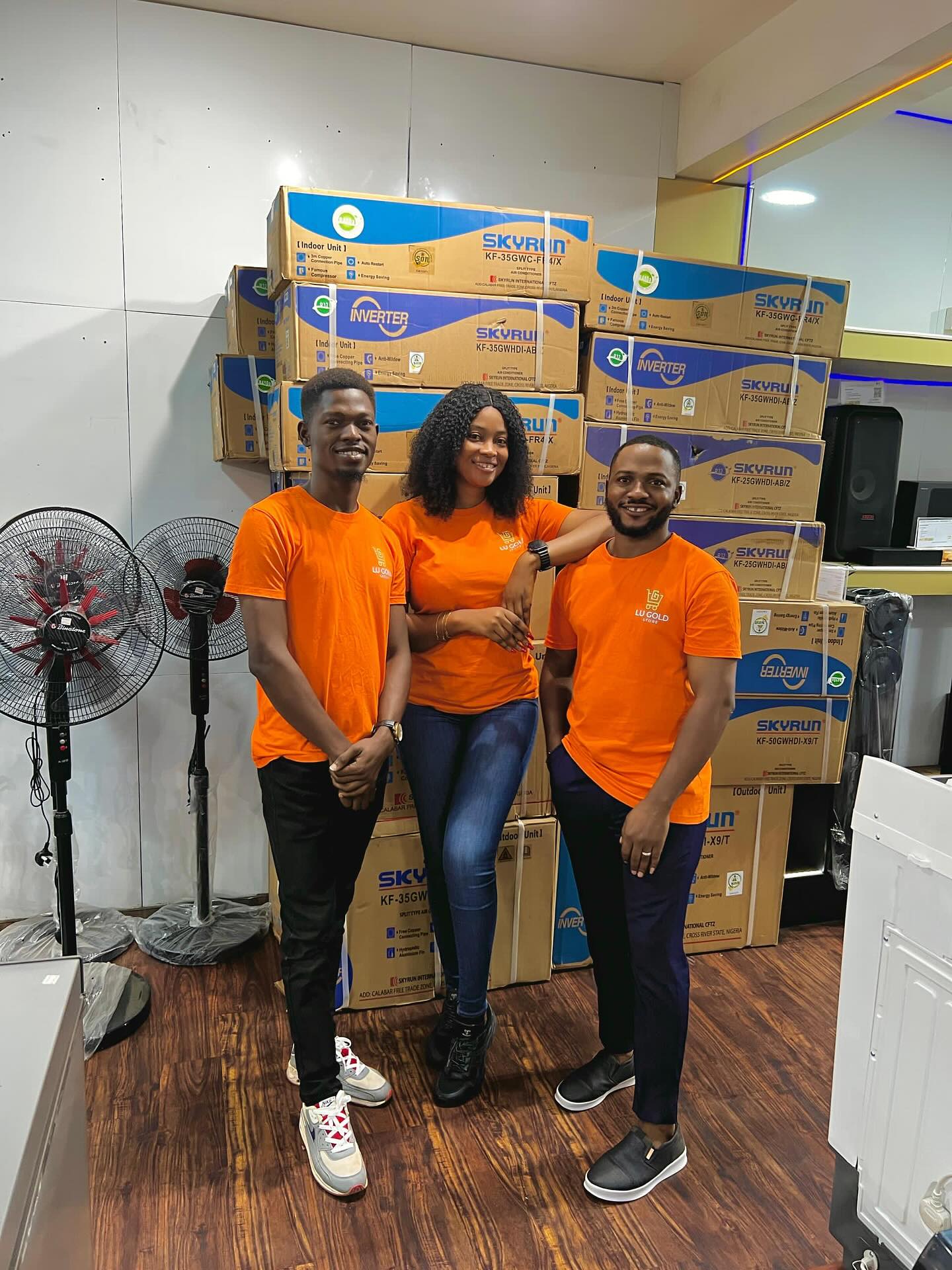 Lu Gold Store team beside stacked Skyrun inverter air conditioner boxes